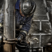 Oil Rig Worker wearing his safety gear working on the muddy drill floor   Trabalhador de plataforma petrolífera usando seu equipamento de segurança trabalhando no chão de perfuração lamacento